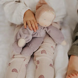 Child with a Grimms soft violet Waldorf doll on their knees