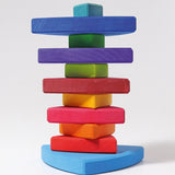 A Grimms wankel tower. Wooden triangluar pieces im Grimms world of numbers palette threaded through a pole on a base