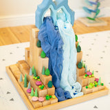 A waterfall play scene using Grimms natural blocks, pastel forest set, play cloth and other loose wooden pieces.
