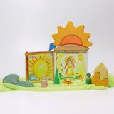 A sunny display showing a Grimms weather book, wooden weather blocks and other yellow and orange coloured blocks