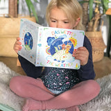 Child sitting on a Wobbel board an reading the pages from the Grimm's weather book 