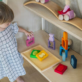 A child playing with the Grimm's Windows Building & Stacking Set stacking pieces on top of each other. These Grimm's toys are part of a wide range of wooden toys available here at Babipur. 