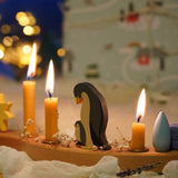 A festive Christmas display with Grimm's celebration ring pieces and the penguin family decorative figure