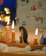 A festive Christmas display with Grimm's celebration ring pieces and the penguin family decorative figure