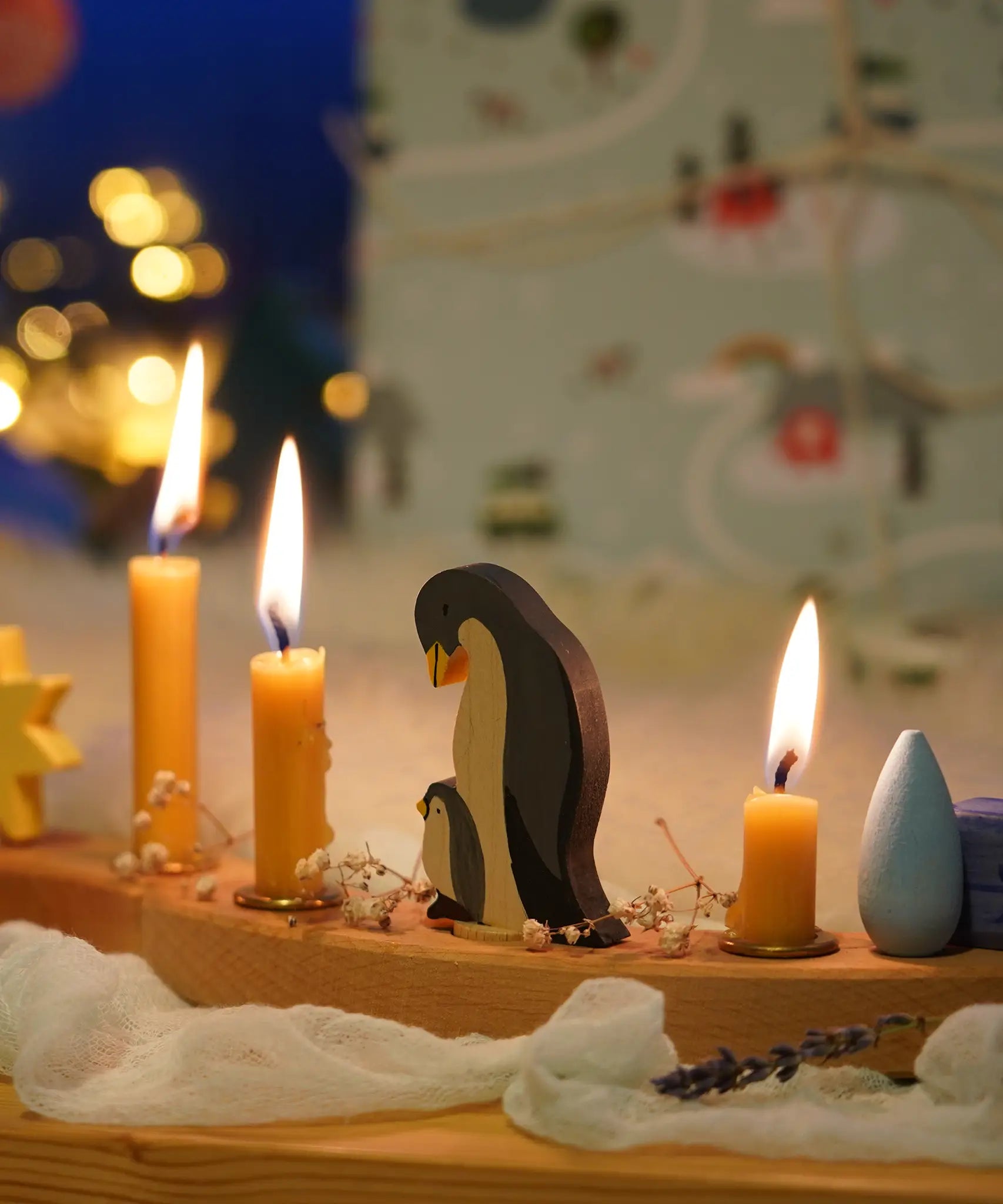 A festive Christmas display with Grimm's celebration ring pieces and the penguin family decorative figure