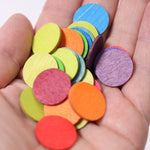 A close up of some Grimm's Rainbow Confetti Dots in an adult's hand. 