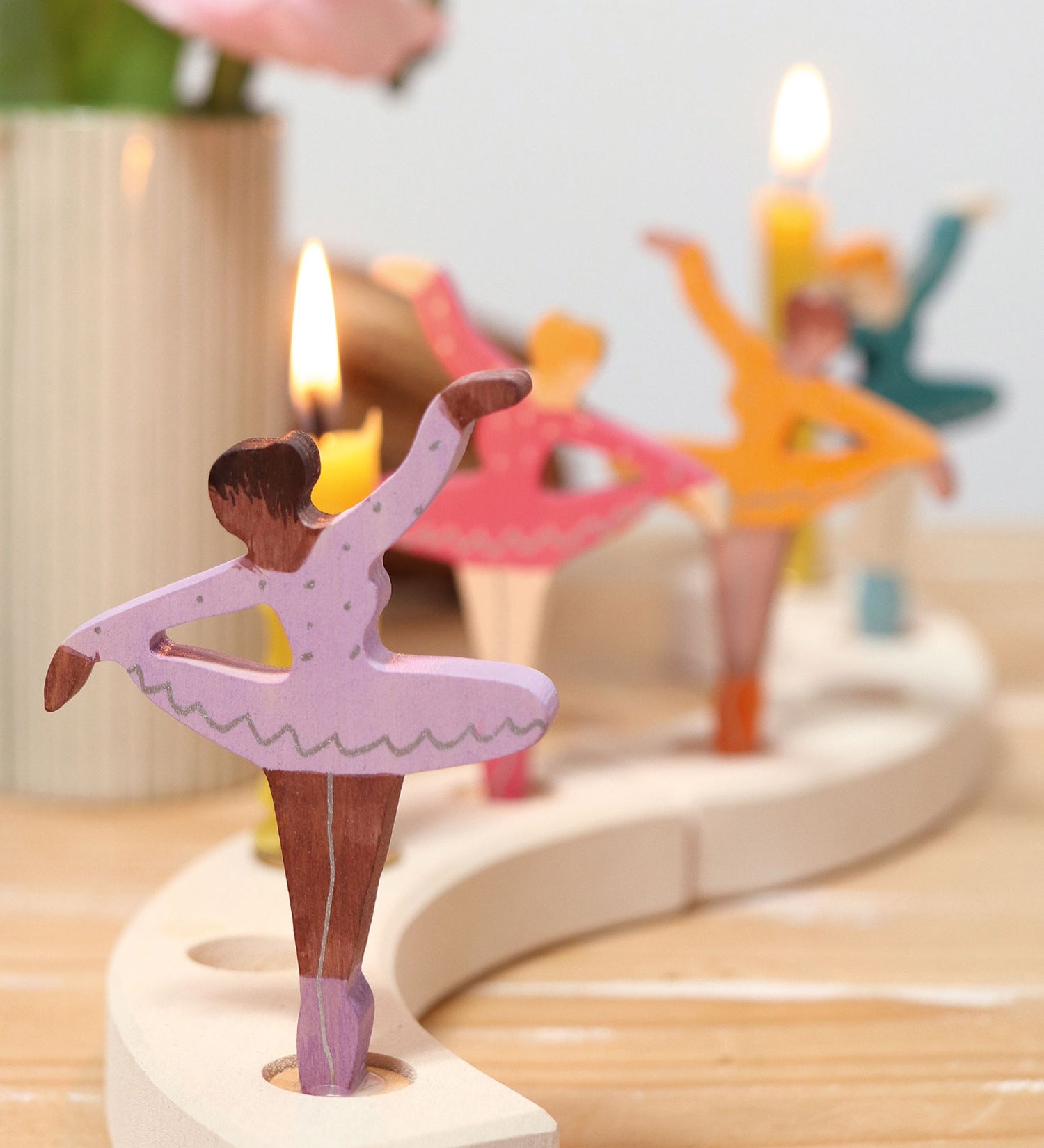 A cosy display showing the different coloured ballerina Grimms wooden decorative figures slotted in the the celebration ring