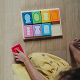 An overhead view of a child with the Grimm's windows building set blocks set on the floor in front of them. These Grimm's toys are part of a wide range of wooden toys available here at Babipur. 