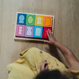An overhead view of a child with the Grimm's windows building set blocks set on the floor in front of them. These Grimm's toys are part of a wide range of wooden toys available here at Babipur. 
