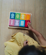 An overhead view of a child with the Grimm's windows building set blocks set on the floor in front of them. These Grimm's toys are part of a wide range of wooden toys available here at Babipur. 