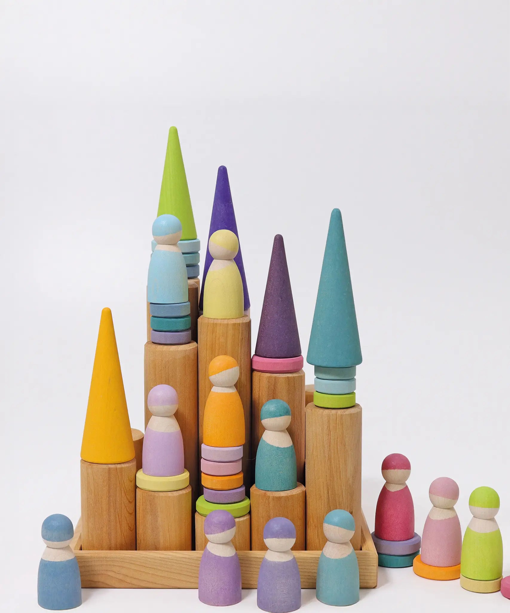 Grimm's large wooden building rollers in natural in a tray with pastel friends and forest pieces placed on top of them.