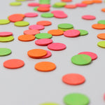 A close up of the Grimms wooden confetti dots. Showing the hand painted neon finish 