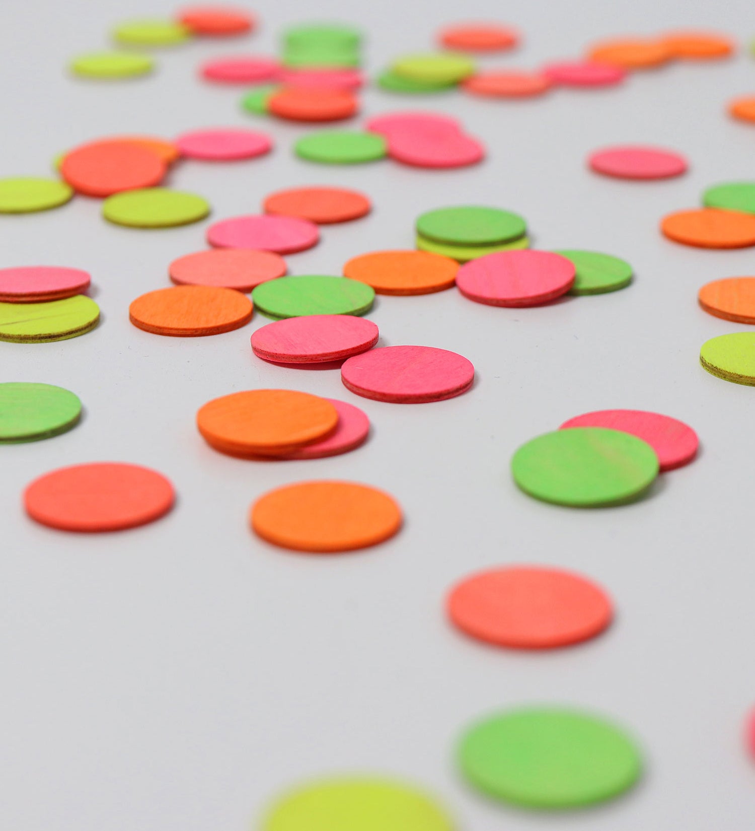 A close up of the Grimms wooden confetti dots. Showing the hand painted neon finish 