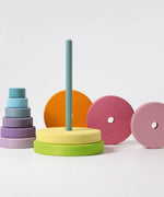 Loose wooden disk pieces from the Grimms large conical tower stacked behind the base with peg