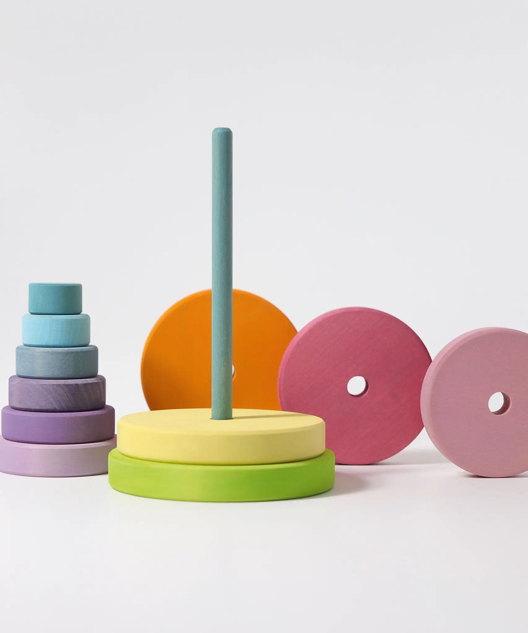 Loose wooden disk pieces from the Grimms large conical tower stacked behind the base with peg