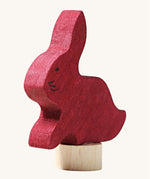 A close up of the Grimms wooden sitting rabbit decorative figure in dark red. Showing the hand painted detail and thickness of the figure