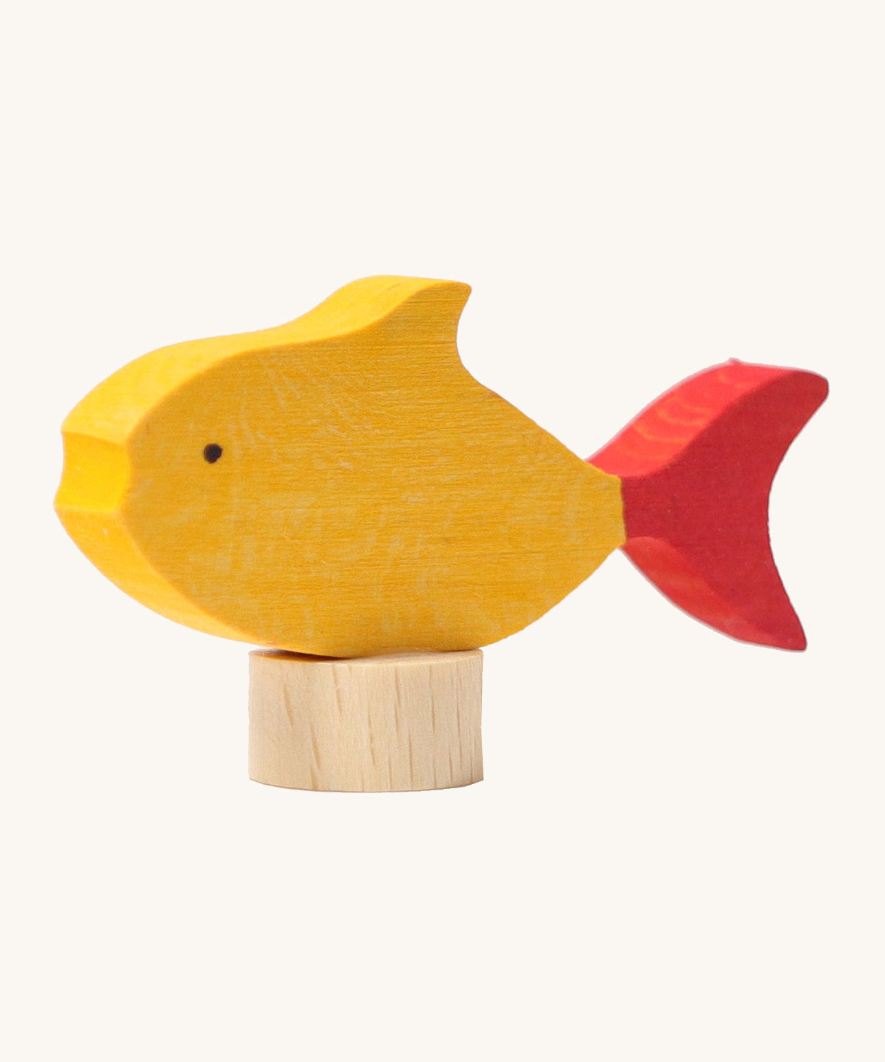 A close up of the Grimms wooden yellow fish decorative figure with red fins. Showing the hand painted detail and thickness of the figure