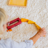 Woman placing loose Grimms desert sand wooden blocks in a line