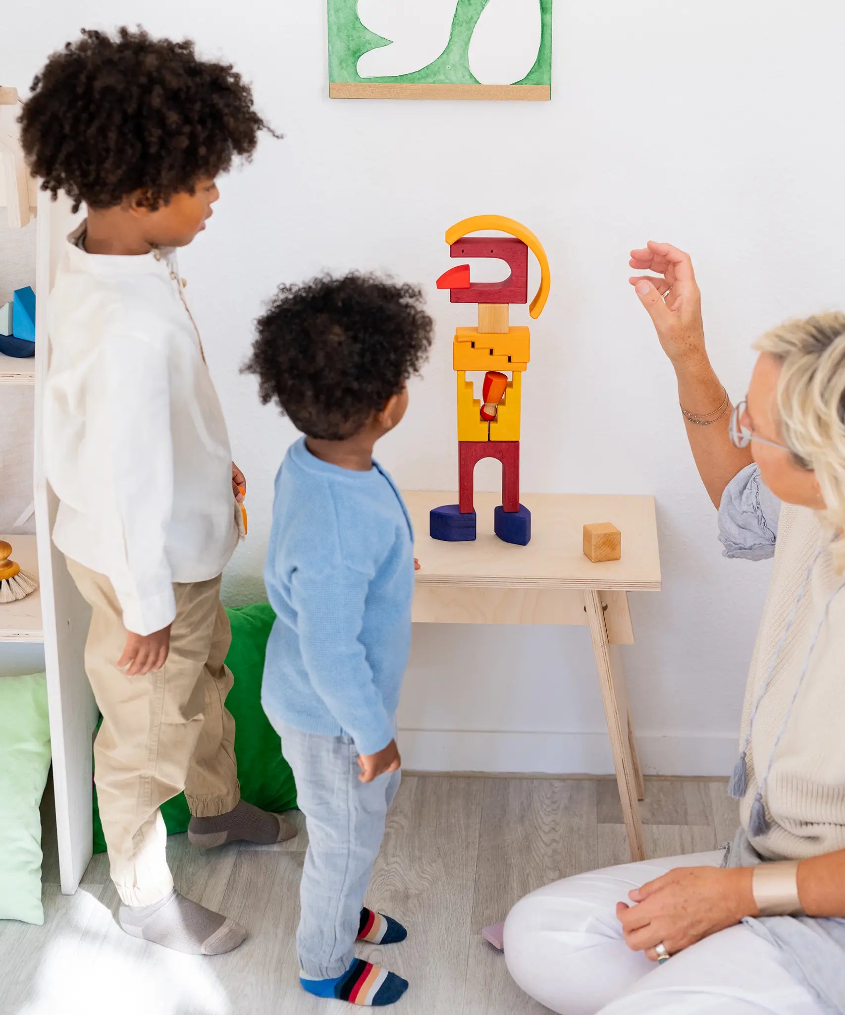 Family building a abstract person made from the Grimms desert sand wooden block set