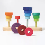 3 loose disks in dark red and purple with holes from the Grimms fabuto set in front of the stacking base