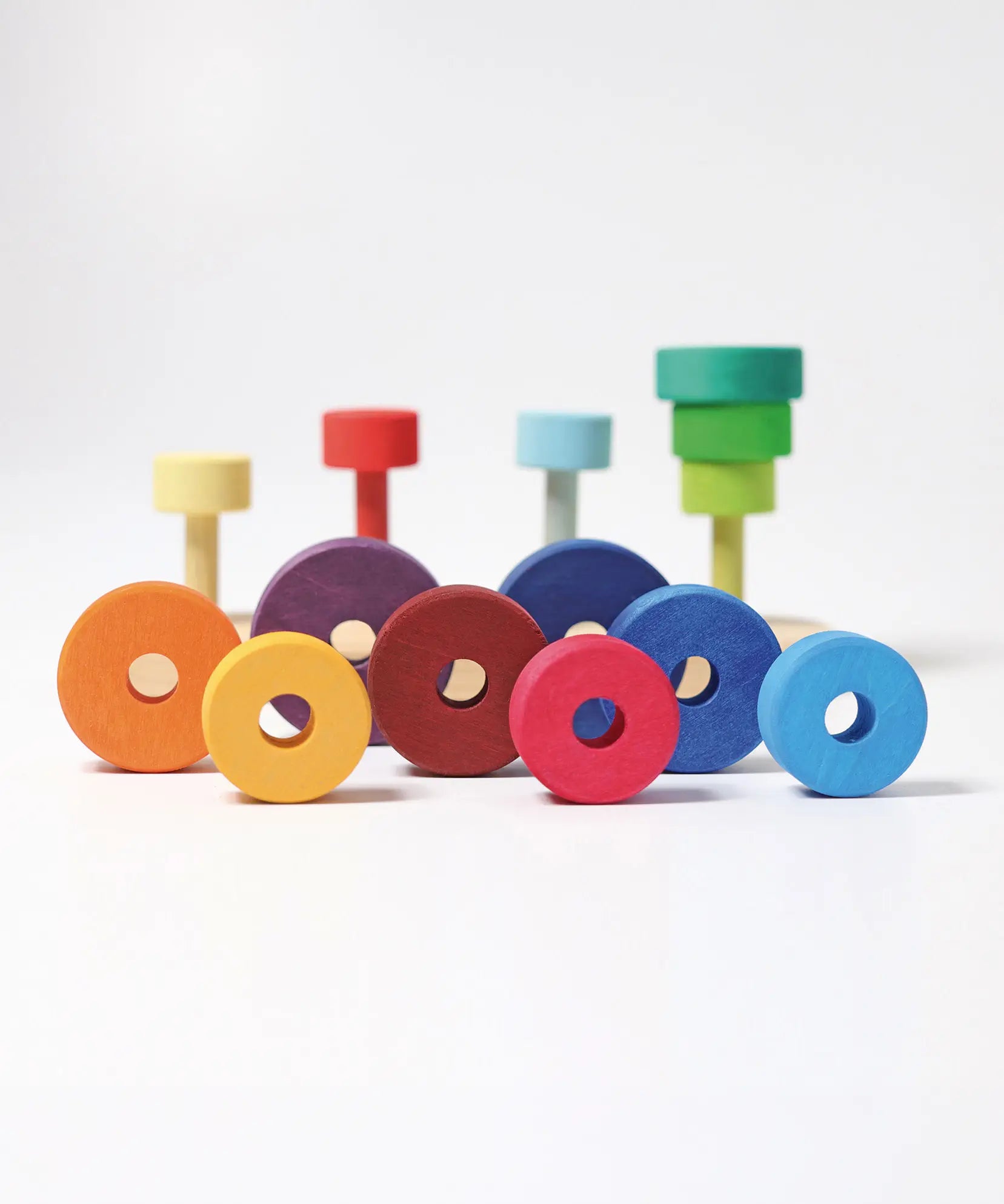 Grimms fabuto stacking set in a rainbow palette showing loose disk pieces with a hole in the middle 