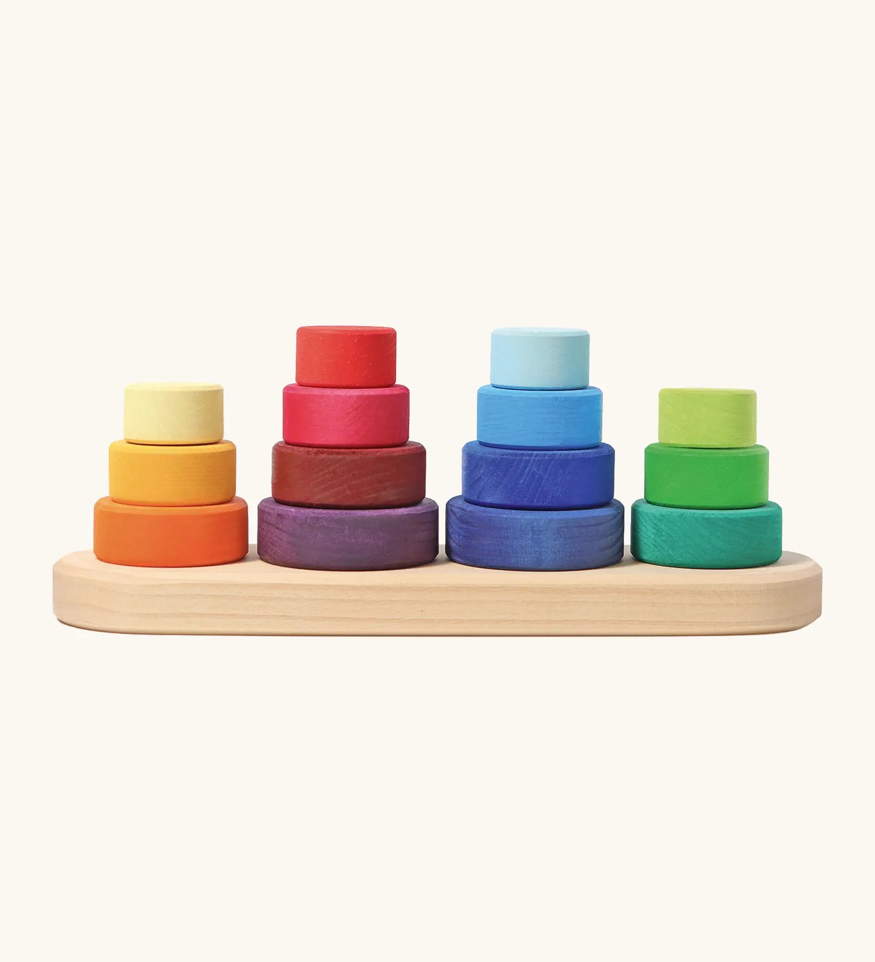 Grimms fabuto stacking toy. Includes 14 wooden disks in a rainbow palette and a base with pegs. Perfect for stacking and learning games