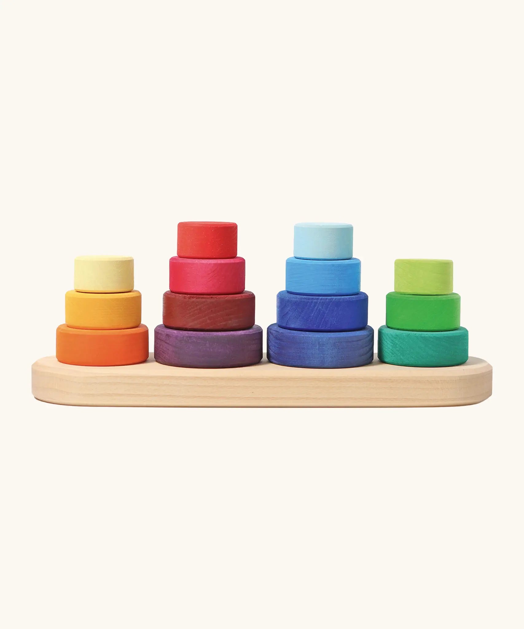 Grimms fabuto stacking toy. Includes 14 wooden disks in a rainbow palette and a base with pegs. Perfect for stacking and learning games