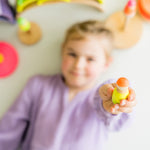 orange yellow and green being played with by a child with the Neon Green rainbow and Neon Pink stacking tower.