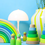 A play scene using the Grimms neon green rainbow, peg dolls and stacking towers
