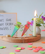 Grimm's Sweet Cone wooden Decorative Figure - Neon Green. The cone sits inside the Celebration ring alongside the Neon Pink Cone and a candle.