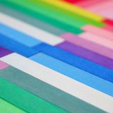 Grimm's handcrafted wooden Leonardo sticks laid flat showing the hand dipped pastel and rainbow colours on the sticks