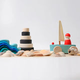 Grimms' handcrafted wooden little land yacht standing next to a monochrome stacking tower and wave set
