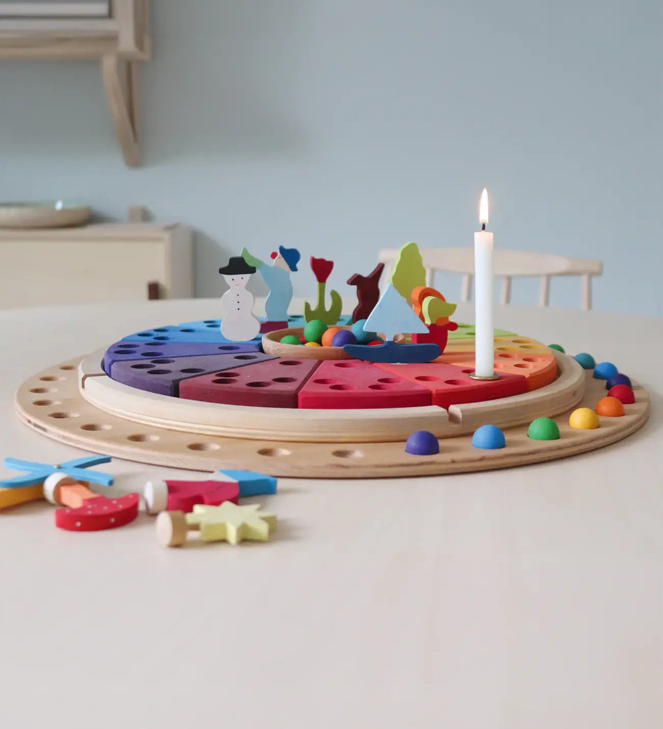 A display using a Grimms circular disk, rainbow marbles and decorative figures. 