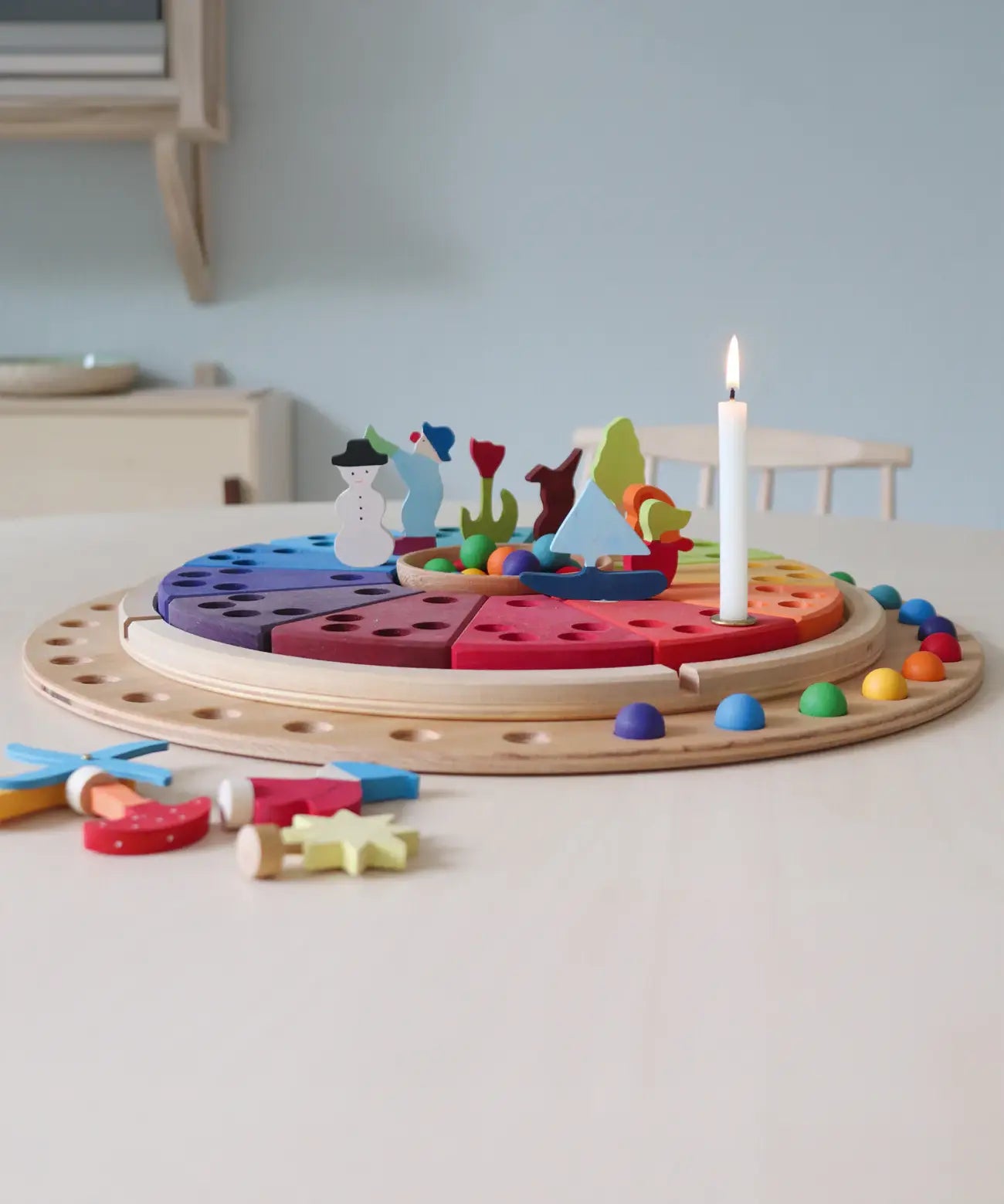 A display using a Grimms circular disk, rainbow marbles and decorative figures. 