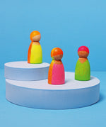 Grimms wooden friends in a hand painted neon mix finish standing on 2 wooden blue platforms
