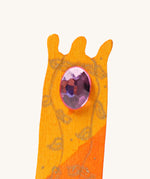 A close up of the orange tower decorative figure showing the purple gem and hand painted leaves detail