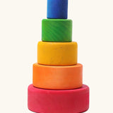 A stack of Grimms wooden bright rainbow bowls