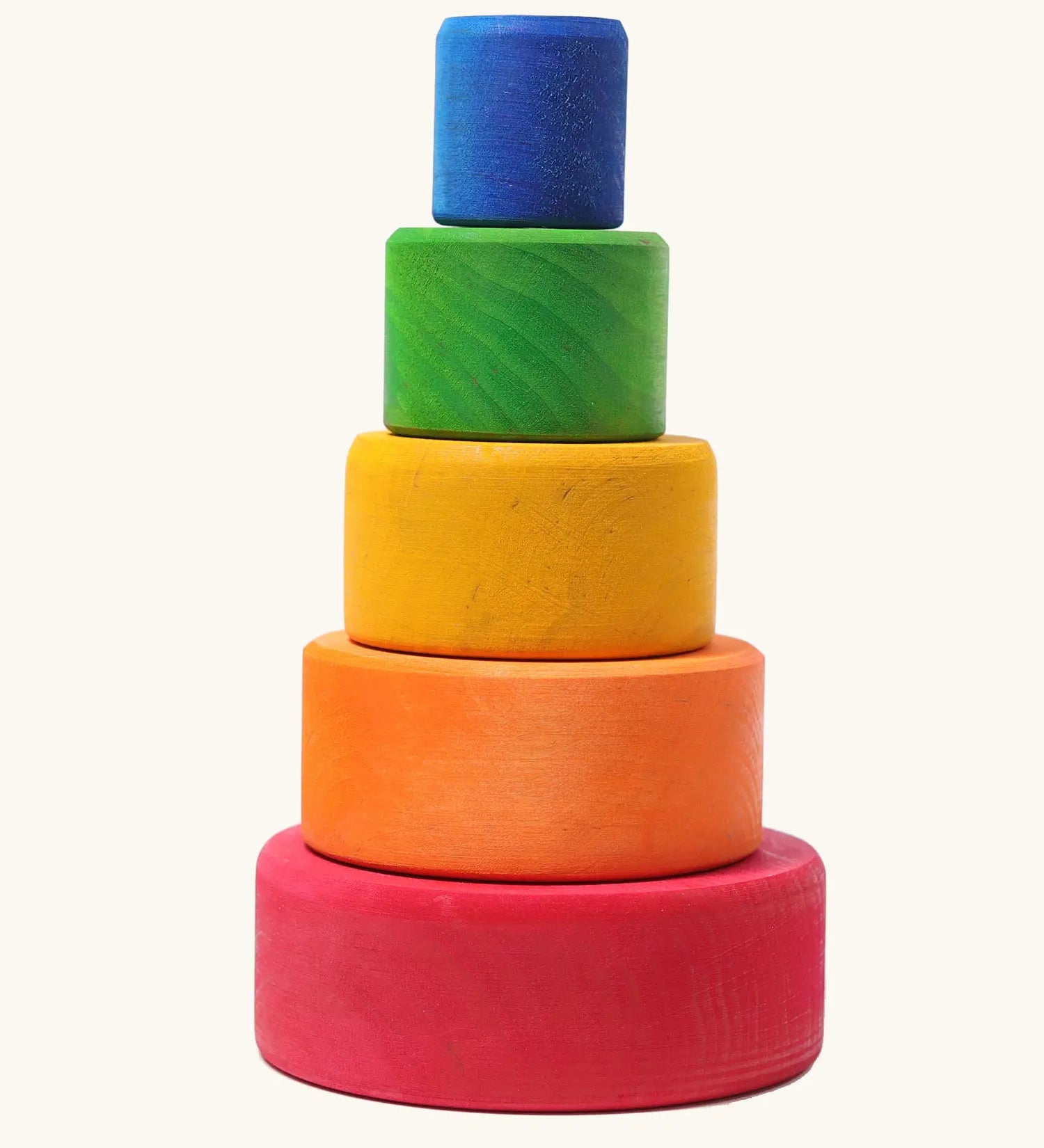 A stack of Grimms wooden bright rainbow bowls