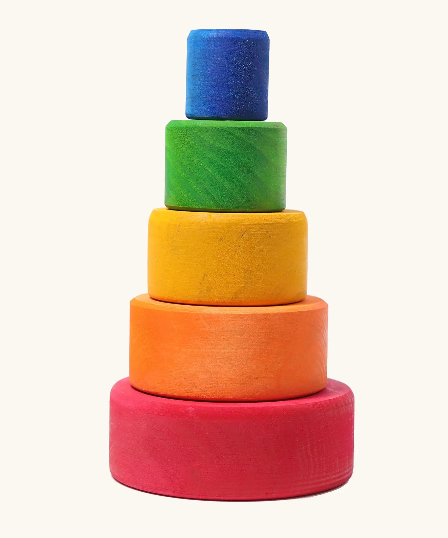 A stack of Grimms wooden bright rainbow bowls