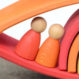 Grimms handcrafted wooden rainbow bridges showing close up detail of 2 peg dolls in between arched pieces