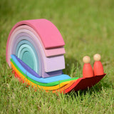 Grimms handcrafted wooden rainbow bridges and pastel arches made into a snail on grass