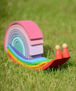 Grimms handcrafted wooden rainbow bridges and pastel arches made into a snail on grass
