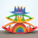 Grimms handcrafted wooden rainbow bridges stacked with peg dolls in between 
