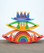 Grimms handcrafted wooden rainbow bridges stacked with peg dolls in between 