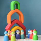 A castle playscene made from Grimm's wooden house pieces in a rainbow palette with matching peg dolls