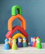 A castle playscene made from Grimm's wooden house pieces in a rainbow palette with matching peg dolls