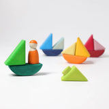 4 little sailboats made from the Grimms handcrafted wooden rolling boats pieces with a peg doll standing on one boat