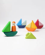 4 little sailboats made from the Grimms handcrafted wooden rolling boats pieces with a peg doll standing on one boat