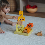 A child playing with the yellow and natural wooden blocks from the Grimm's yellow building set. The child is stacking them on top of each other on the yellow coloured storage tray that they come with. These Grimm's toys are part of a wide range of wooden toys available here at Babipur. 