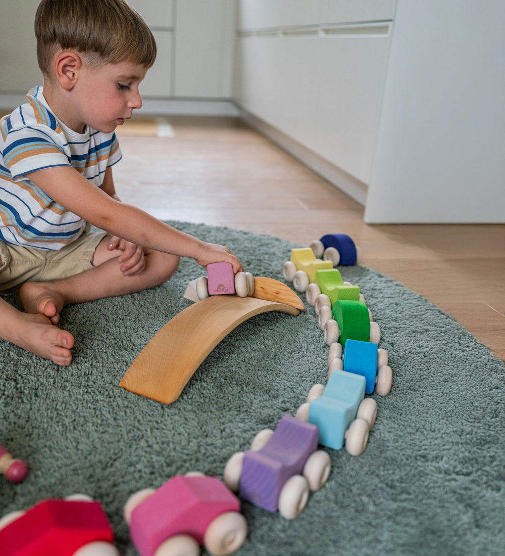A child playing with the Grimm's Stacking Cars. Wooden toy cars that comes in a two back that can can be stacked on top of each other.
These Grimm's toys are part of a wide range of wooden toys available here at Babipur. 